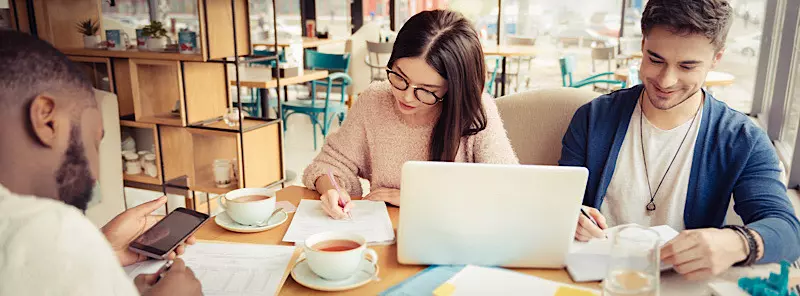 Young people are repeating their vocabulary using SRS while sitting in a coffee shop