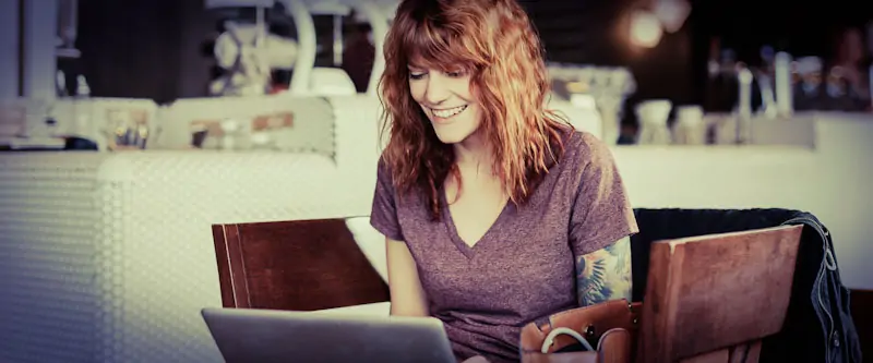 A young woman in front of her laptop taking part in a virtual classroom session.