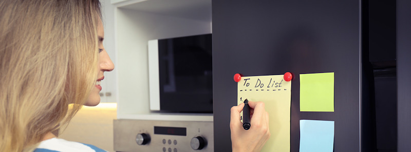 woman using the self nudging technique using post-its and a to-do list