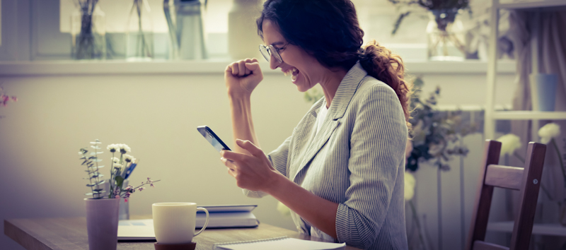 Woman is happy to use the best vocabulary trainer on her phone