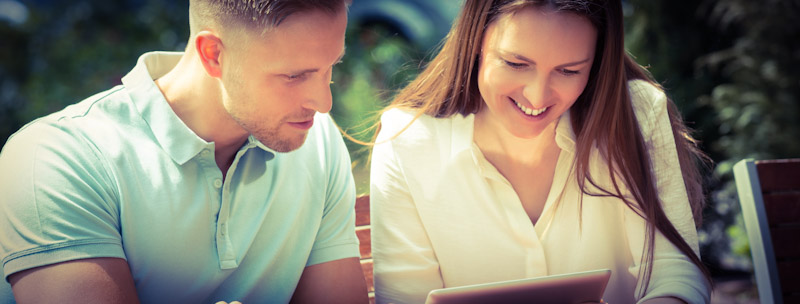 Young man and woman using an AI language course on a tablet.