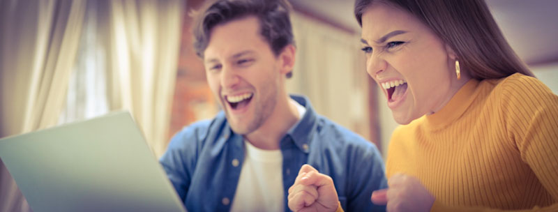 a young man and woman are happy about the language course discounts they have found on talkreal